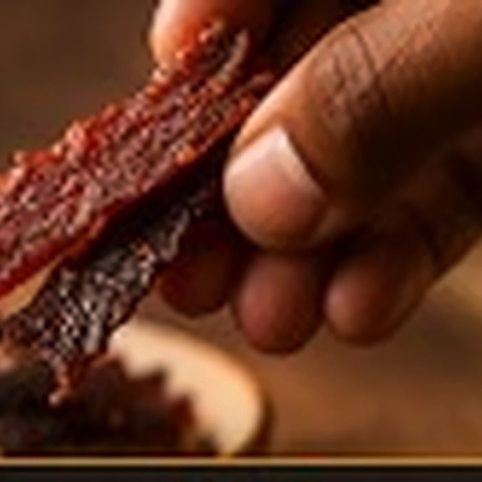 Kilishi strips being picked up by hand